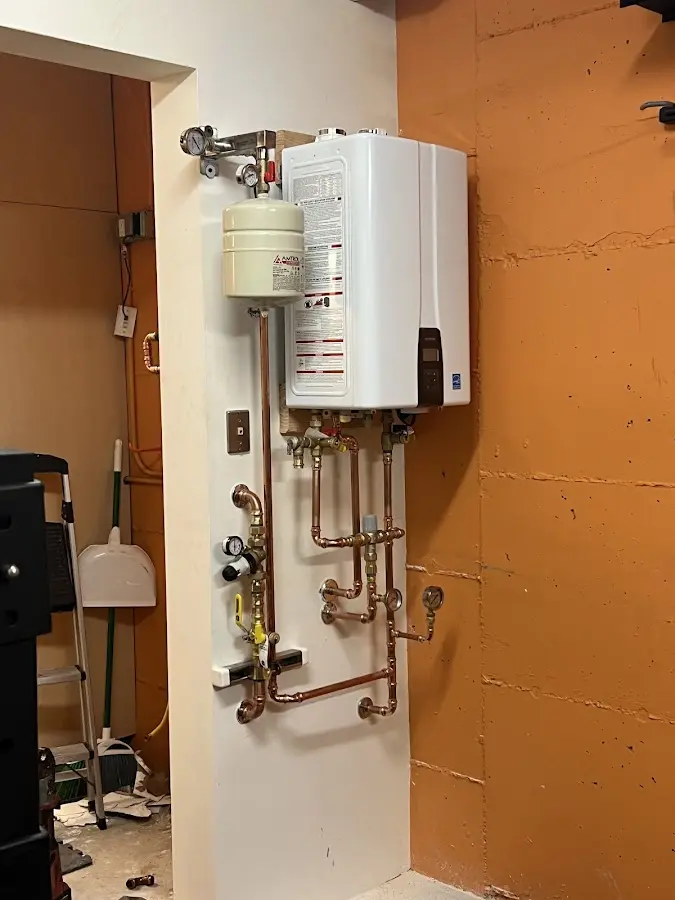 Plumbing technician inspecting water heater connections in Sonterra